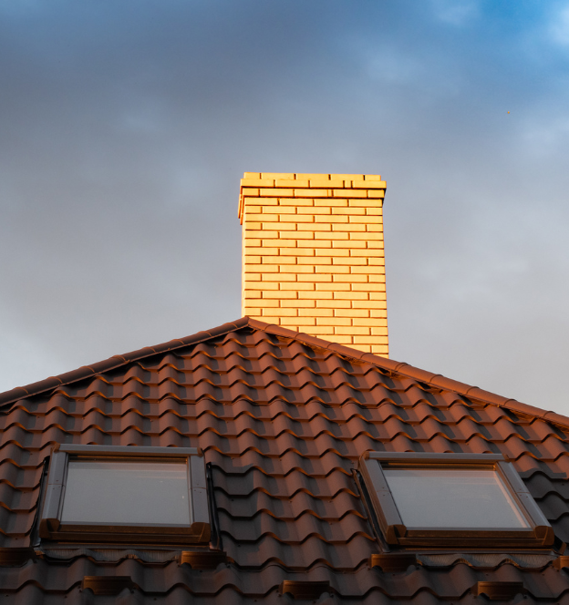Dakreparatie Hilversum – rood pannendak met schoorsteen en dakramen